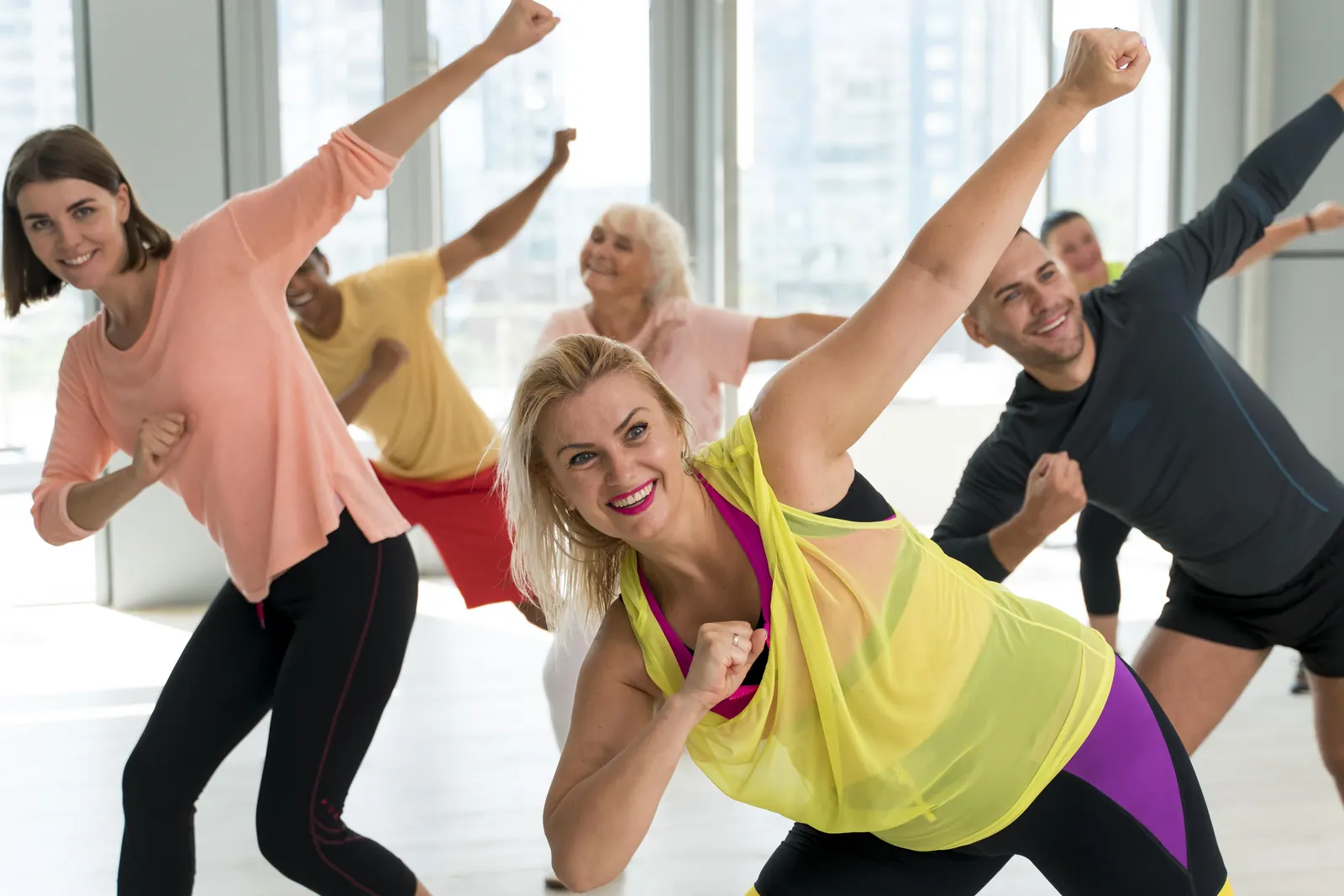 Grupo de pessoas a sorrir durante uma aula de dança